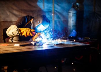 Worker cutting metal with plasma equipment. on plant